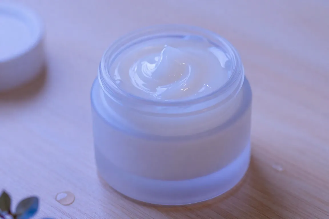 Glass jars of overnight hydrating sleep masks displayed on a clean wooden table.